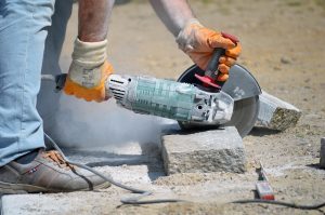 Worker Cutting Granite Stone Containing Quartz